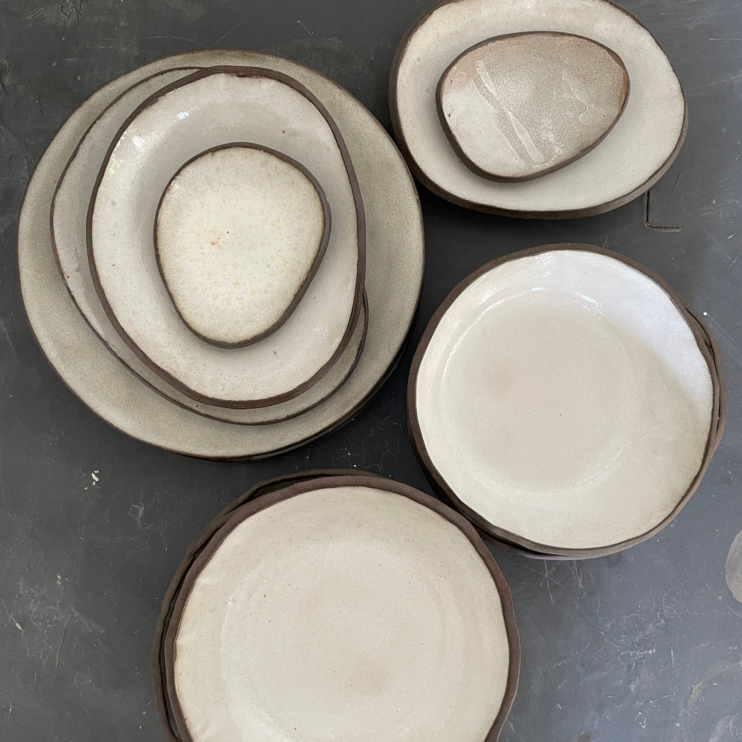 Set of white handmade ceramic dinner plates, bowls, and side plates